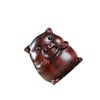 Close up of a small carved wooden pig figurine with a smiling face