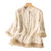 Beige embroidered cotton linen shirt with lace trim hanging on a wooden hanger