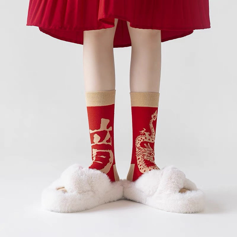 Person wearing red mid-calf socks with a dragon pattern