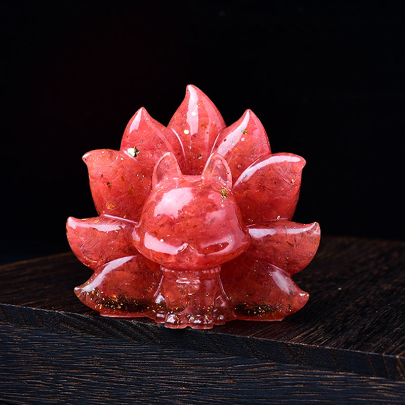 Close-up of a pink strawberry quartz nine-tailed fox carving on a dark wood surface