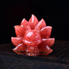 Close-up of a pink strawberry quartz nine-tailed fox carving on a dark wood surface
