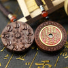 Round jujube wood pendant showing carved hand mudras and a cinnabar coin design