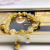 Yellow citrine and tiger eye beaded bracelet with a flower charm on a book
