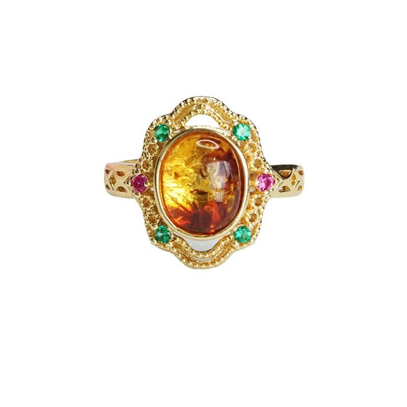 Gold-tone ring with an oval amber stone and green and pink accents