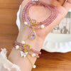 Pink strawberry quartz double wrap bracelet with gold tone butterfly charm on wrist