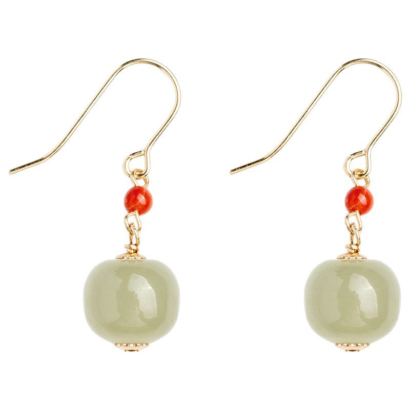 Pale green round jade earrings with red agate beads hanging from gold hooks
