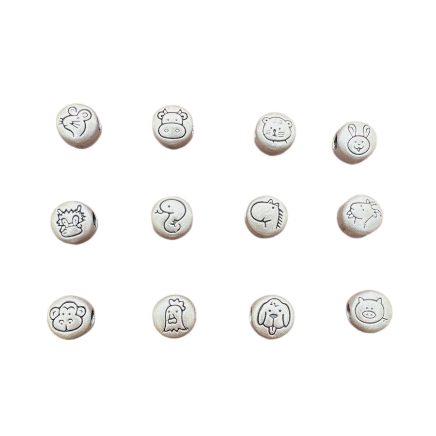 Twelve round silver charms showing the Chinese zodiac animals arranged on a white background