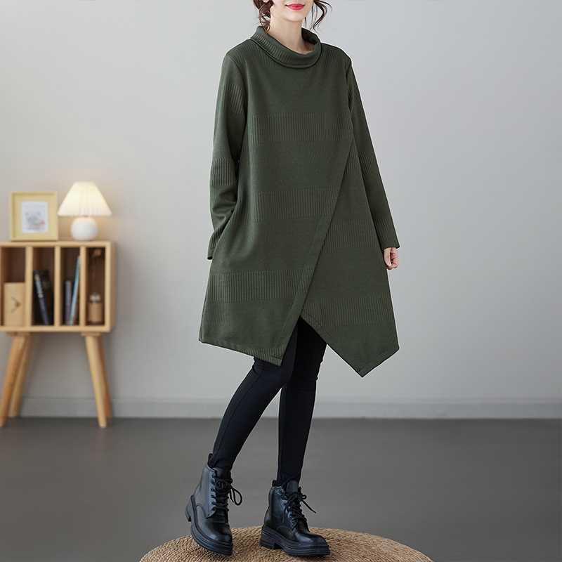 Woman wearing a dark green asymmetric midi dress with a mock neck