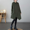 Woman wearing a dark green asymmetric midi dress with a mock neck