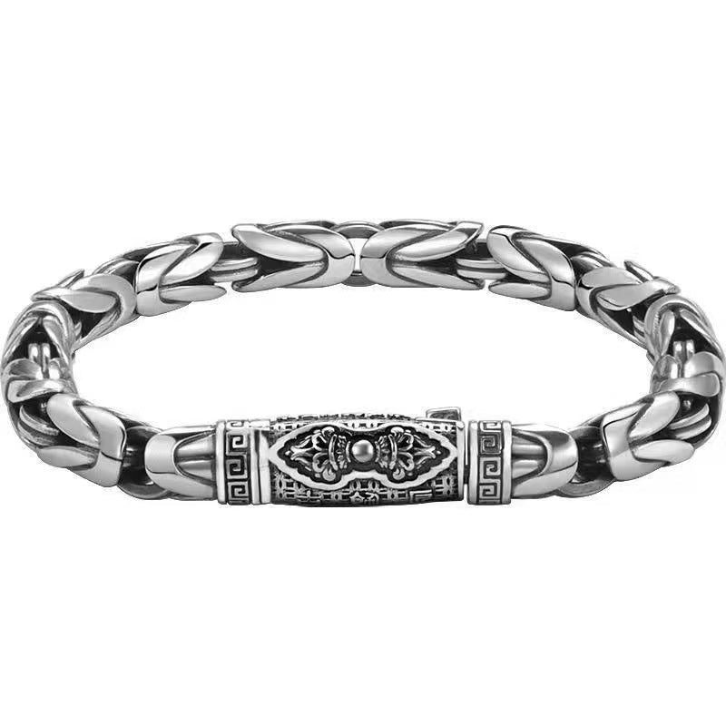 Silver tone copper bracelet with twisted links and a Vajra center on a wooden box