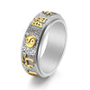 Close up of a silver tone stainless steel ring with a spinning band featuring gold accents and a yin yang symbol