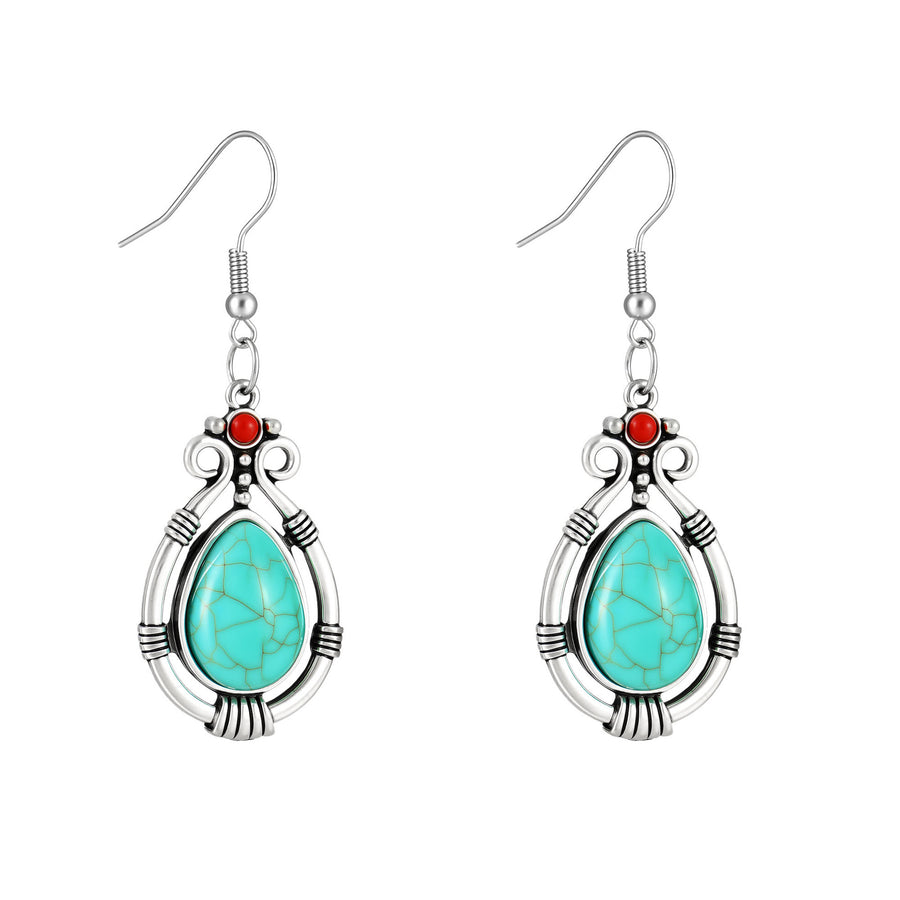 A pair of silver-tone teardrop earrings with a turquoise-colored stone and red accent bead