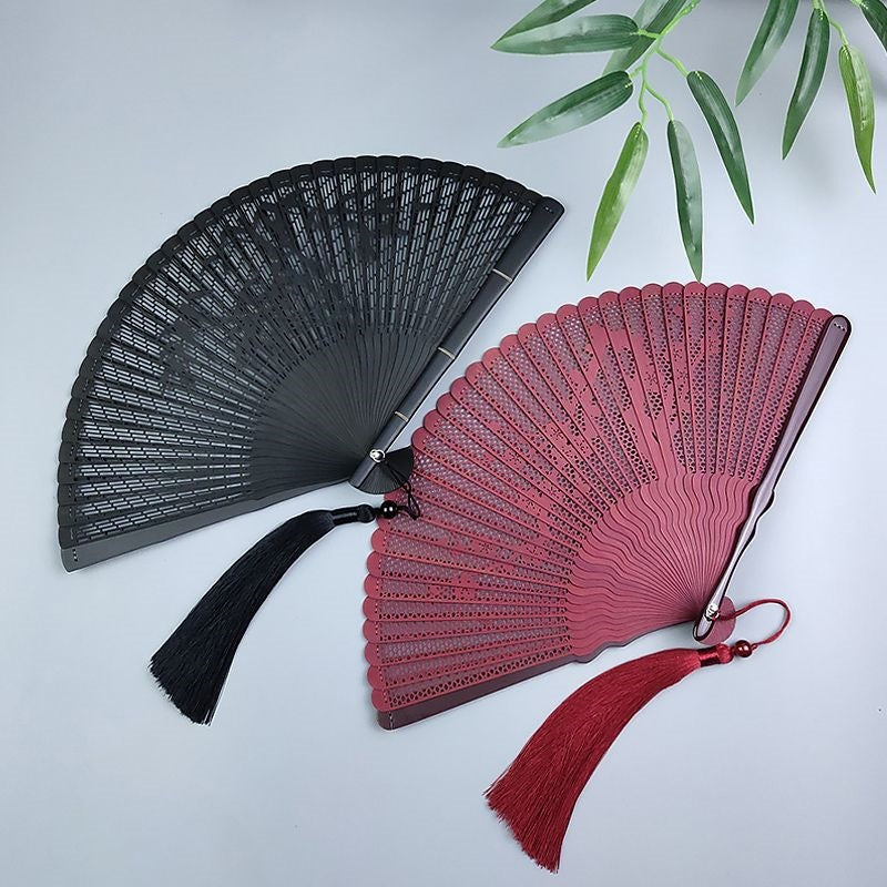 Black and red bamboo folding fans with hollow carved designs and tassels