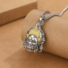 Close up of a copper Yellow God of Wealth pendant with gold accents on a silver tone box chain