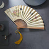 Open handmade bamboo folding fan with fabric showing butterfly and cat artwork