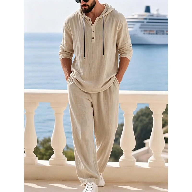 Man wearing a beige hooded lounge set with half buttons standing on a balcony
