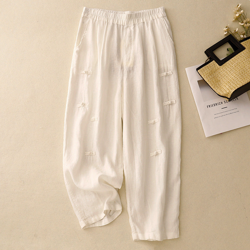 White cotton linen harem pants with frog buttons laid flat