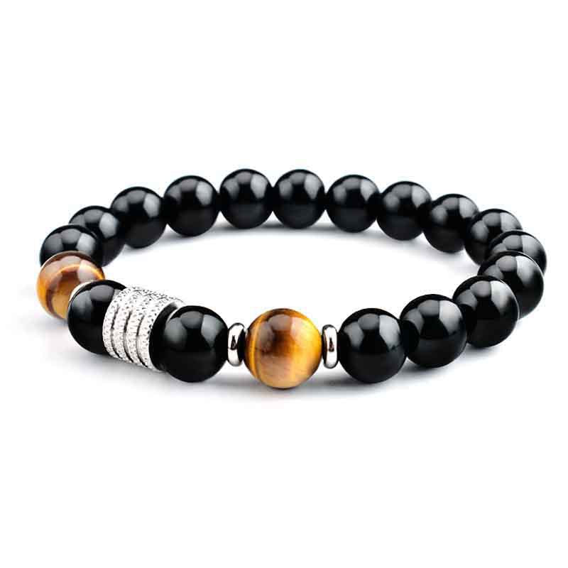 Close-up of a wrist wearing a black and gold Tiger Eye beaded bracelet with a silver tone spacer