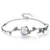 Antique silver tone bracelet with white chalcedony stone and floral details on a white background