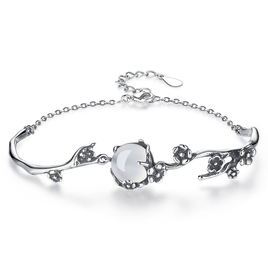 Antique silver tone bracelet with white chalcedony stone and floral details on a white background