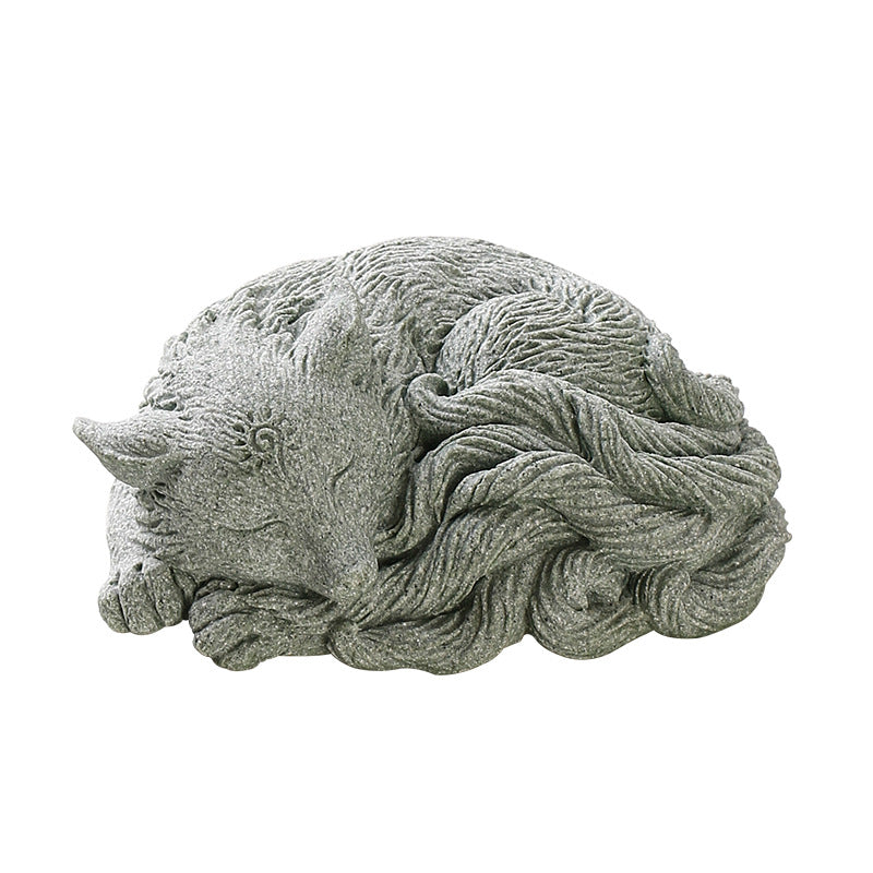 Close up of a grey ceramic sleeping fox tea pet figurine