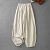 Beige women's harem pants with pockets laid flat on grey background
