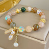 Close up of a beaded bracelet with a gold tone peanut charm and mixed crystal beads