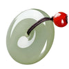 Close-up of a light green polished glass peace buckle pendant on a dark cord