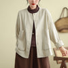Model wearing a loose beige cotton linen jacket with rolled sleeves and front pockets