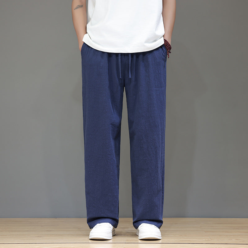 Man wearing navy blue straight leg linen pants with hands in pockets