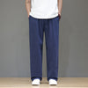Man wearing navy blue straight leg linen pants with hands in pockets