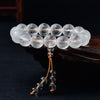 Close-up of clear crystal beads with engraved mantras on a wooden display stand