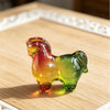 Small colorful crystal glass horse figurine sitting on a wooden surface