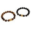 Close up of a yellow tiger eye bead bracelet with a gold tone center charm on a white tray.