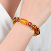 Amber glass bracelet with Pixiu charm worn on wrist