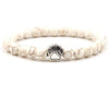 White howlite beaded bracelet with silver dog paw charm on white background