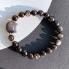 Close up of a black obsidian bracelet with a silver sheen cat head charm