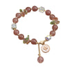 Pink Strawberry Quartz beaded bracelet with a gold-tone four leaf clover charm