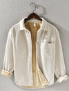 Men's long sleeve corduroy shirt in khaki color hanging on a hanger