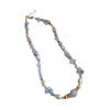 Blue aquamarine chip necklace with pearls on a textured surface
