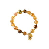 Close up of a yellow citrine beaded bracelet with a gold charm on a wrist