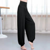 Side view of black loose harem pants with a high waist worn by a dancer.