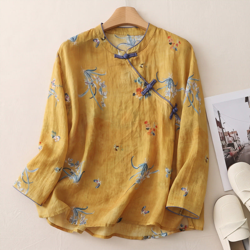 Front view of a yellow long sleeve linen top with blue floral patterns and knotted buttons