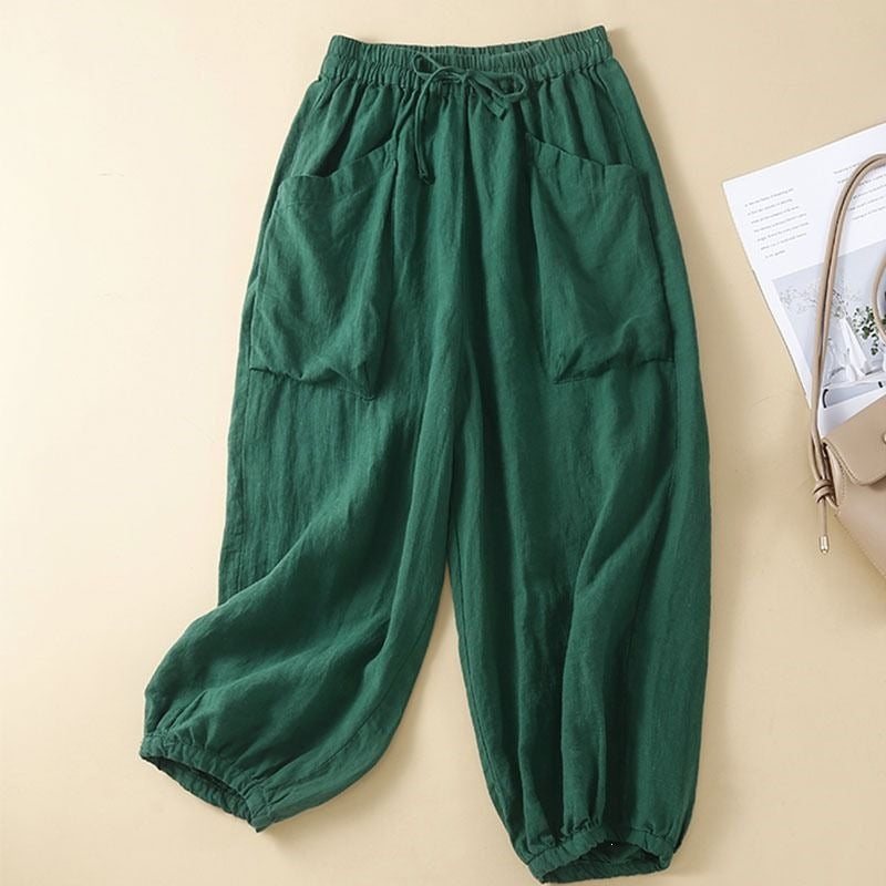 Green cropped harem pants with elastic waist and pockets laid flat