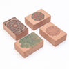 Four cork yoga blocks with mandala prints arranged on a white background