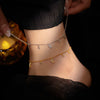 Close up of silver and gold plated sterling silver anklets with pepper charms on an ankle
