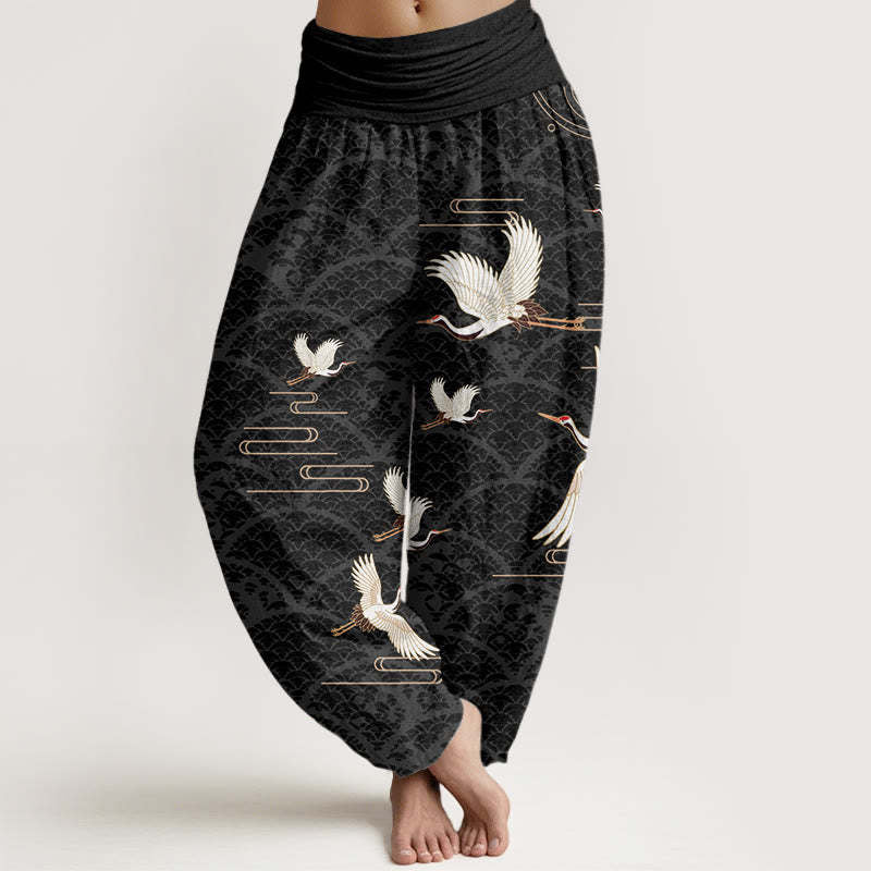 Model wearing black harem pants with white crane pattern