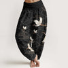 Model wearing black wide-leg harem pants with white crane print