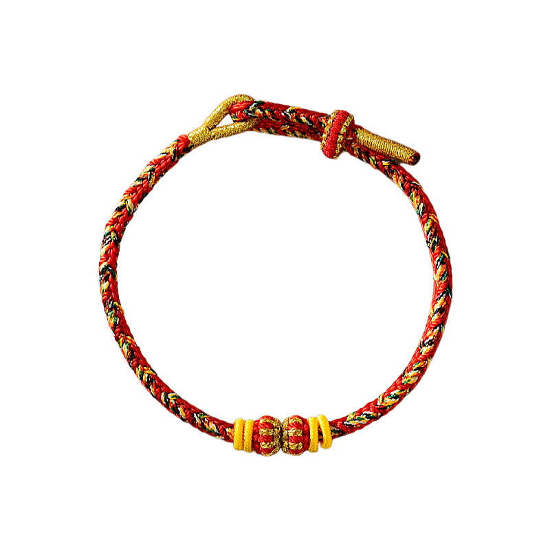 Close up of a red and gold braided rope bracelet with small beads