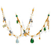 Close up view of gold tone necklace with white faux pearls and green teardrop charm